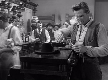 Movie still from “High Noon” (1952), directed by Fred Zinnemann – An old photo of a man in a hat shop; Medium shot, Low angle