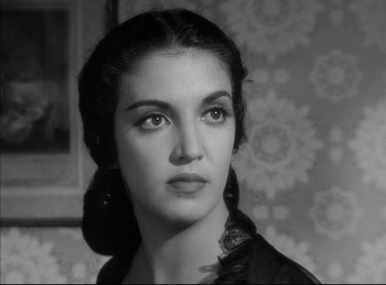 Movie still from “High Noon” (1952), directed by Fred Zinnemann – A black - and - white photo of a woman in a black dress; Close Up shot, Low angle