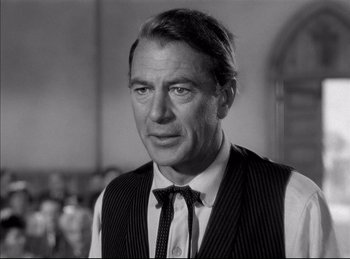 Movie still from “High Noon” (1952), directed by Fred Zinnemann – Black and white photograph of a man wearing a vest and tie; Close Up shot, Over the shoulder angle