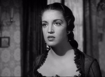 Movie still from “High Noon” (1952), directed by Fred Zinnemann – A young woman in a black dress looking to her left; Close Up shot, Low angle