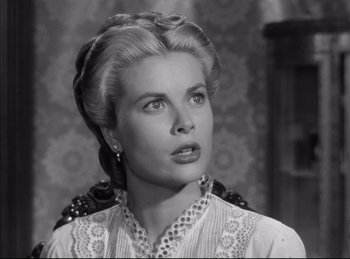 Movie still from “High Noon” (1952), directed by Fred Zinnemann – A woman in a white dress with a long necklace; Close Up shot, Low angle