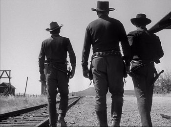 Movie still from “High Noon” (1952), directed by Fred Zinnemann – A group of men walking down a train track; Medium shot, Low angle