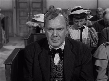 Movie still from “High Noon” (1952), directed by Fred Zinnemann – An older man sitting in front of a woman; Close Up shot, Over the shoulder angle