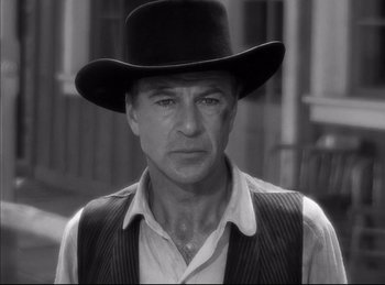 Movie still from “High Noon” (1952), directed by Fred Zinnemann – A man wearing a black hat and a vest; Close Up shot, Low angle