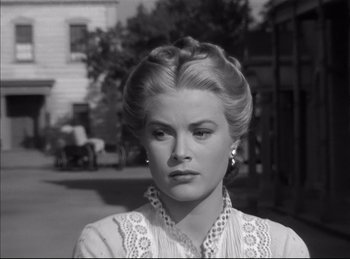 Movie still from “High Noon” (1952), directed by Fred Zinnemann – A black and white photo of a woman in a white dress; Close Up shot, Over the shoulder angle