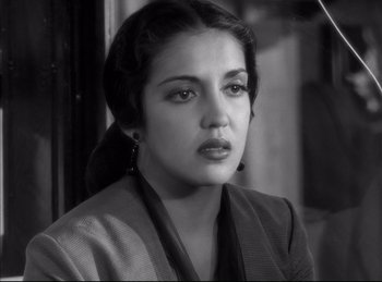 Movie still from “High Noon” (1952), directed by Fred Zinnemann – A black - and - white photo of a woman in a suit; Close Up shot, High angle