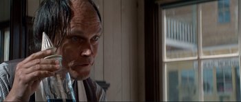 Movie still from “High Plains Drifter” (1973), directed by Clint Eastwood – A person wearing a suit and tie; Close Up shot, Over the shoulder angle