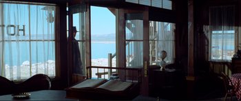 Movie still from “High Plains Drifter” (1973), directed by Clint Eastwood – An open window with a view of the ocean; Wide shot, Over the shoulder angle