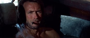 Movie still from “High Plains Drifter” (1973), directed by Clint Eastwood – A person smoking a cigarette; Close Up shot, Low angle