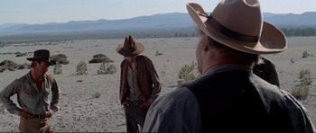 Movie still from “High Plains Drifter” (1973), directed by Clint Eastwood – A man in a cowboy hat standing next to another man in a cowboy hat; Wide shot, Over the shoulder angle