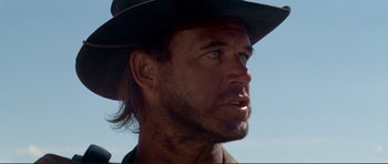 Movie still from “High Plains Drifter” (1973), directed by Clint Eastwood – A person wearing a hat and looking to his left; Close Up shot, Low angle