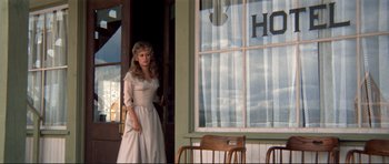 Movie still from “High Plains Drifter” (1973), directed by Clint Eastwood – A woman standing in front of an open window; Wide shot, Low angle