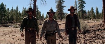 Movie still from “High Plains Drifter” (1973), directed by Clint Eastwood – A group of men walking across a dirt field; Medium shot, Low angle