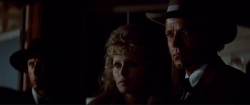 Movie still from “High Plains Drifter” (1973), directed by Clint Eastwood – A man and a woman standing next to each other in the dark; Close Up shot, Low angle