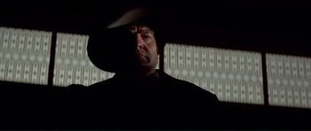 Movie still from “High Plains Drifter” (1973), directed by Clint Eastwood – A man wearing a cowboy hat in the dark; Close Up shot, Low angle