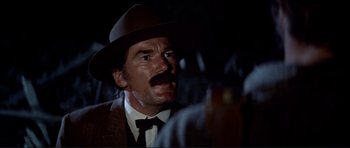 Movie still from “High Plains Drifter” (1973), directed by Clint Eastwood – A man with a mustache wearing a hat; Close Up shot, Over the shoulder angle