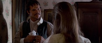 Movie still from “High Plains Drifter” (1973), directed by Clint Eastwood – A man holding a tissue in front of a woman; Close Up shot, Over the shoulder angle