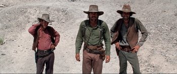 Movie still from “High Plains Drifter” (1973), directed by Clint Eastwood – A group of men standing next to each other on top of a hill; Medium shot, Low angle