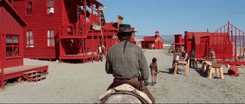 Movie still from “High Plains Drifter” (1973), directed by Clint Eastwood – A man riding a horse in a desert area; Extreme Wide shot, Low angle