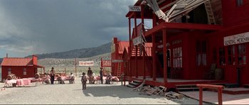 Movie still from “High Plains Drifter” (1973), directed by Clint Eastwood – A group of people standing on top of a sandy beach; Extreme Wide shot, Low angle