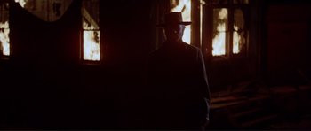 Movie still from “High Plains Drifter” (1973), directed by Clint Eastwood – A man wearing a hat standing in front of a window; Wide shot, Low angle