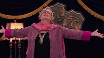Movie still from “High School Musical” (2006), directed by Kenny Ortega – An older woman wearing a pink jacket and a pink scarf; Medium shot, Low angle
