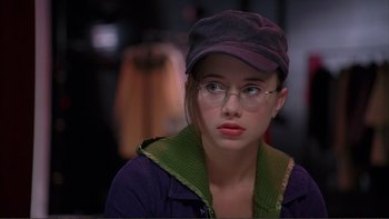 Movie still from “High School Musical” (2006), directed by Kenny Ortega – A young woman wearing glasses and a hat; Close Up shot, Over the shoulder angle