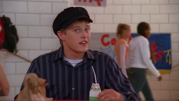 Movie still from “High School Musical” (2006), directed by Kenny Ortega – A young man wearing a black hat and a striped shirt; Close Up shot, High angle