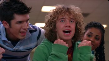 Movie still from “High School Musical” (2006), directed by Kenny Ortega – A young man with curly blonde hair and blue eyes is looking surprised; Close Up shot, Low angle