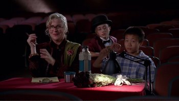Movie still from “High School Musical” (2006), directed by Kenny Ortega – Three people sitting at a dinner table at night; Medium shot, High angle