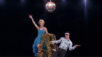 Movie still from “High School Musical” (2006), directed by Kenny Ortega – A man and a woman are posing for a picture; Wide shot, Low angle
