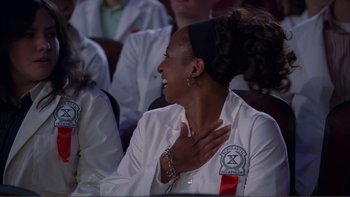 Movie still from “High School Musical” (2006), directed by Kenny Ortega – A woman in a white lab coat is holding her hand over her heart; Close Up shot, Low angle