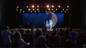Movie still from “High School Musical” (2006), directed by Kenny Ortega – A group of people in front of a stage; Extreme Wide shot, Low angle
