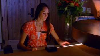 Movie still from “High School Musical 2” (2007), directed by Kenny Ortega – A woman sitting at a table using a computer; Medium shot, High angle