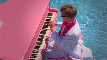 Movie still from “High School Musical 2” (2007), directed by Kenny Ortega – A man in a white suit sitting at a pink piano; Wide shot, High angle