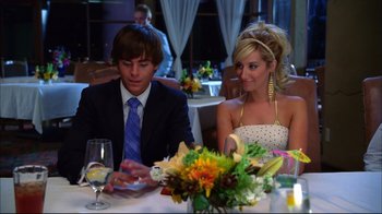 Movie still from “High School Musical 2” (2007), directed by Kenny Ortega – A man and a woman sitting at a dinner table; Medium shot, Over the shoulder angle