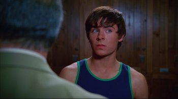 Movie still from “High School Musical 2” (2007), directed by Kenny Ortega – A young man looking into a mirror while wearing a blue tank top; Close Up shot, Over the shoulder angle
