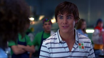 Movie still from “High School Musical 2” (2007), directed by Kenny Ortega – A young man in a striped shirt is smiling; Close Up shot, Over the shoulder angle