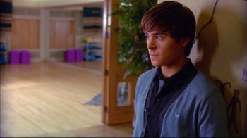 Movie still from “High School Musical 2” (2007), directed by Kenny Ortega – A young man standing in a living room; Medium shot, Over the shoulder angle