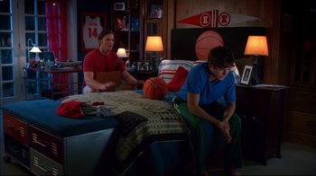 Movie still from “High School Musical 2” (2007), directed by Kenny Ortega – Two young men sitting on a bed in a bedroom; Wide shot, Over the shoulder angle