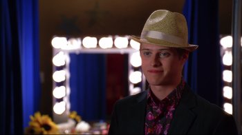 Movie still from “High School Musical 2” (2007), directed by Kenny Ortega – A young man wearing a straw hat in front of a mirror; Close Up shot, Over the shoulder angle