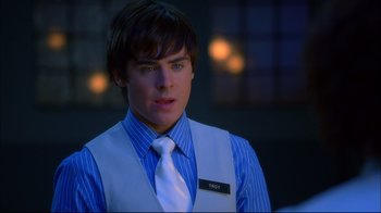 Movie still from “High School Musical 2” (2007), directed by Kenny Ortega – A man wearing a vest and a tie; Close Up shot, Over the shoulder angle