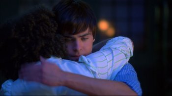Movie still from “High School Musical 2” (2007), directed by Kenny Ortega – A young man holding a stuffed animal in his arms; Medium shot, Over the shoulder angle