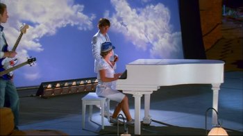 Movie still from “High School Musical 2” (2007), directed by Kenny Ortega – A man and a woman sitting at a white piano; Wide shot, Low angle