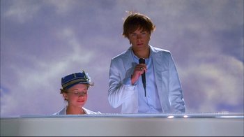 Movie still from “High School Musical 2” (2007), directed by Kenny Ortega – A man and a woman standing next to each other; Medium shot, Low angle