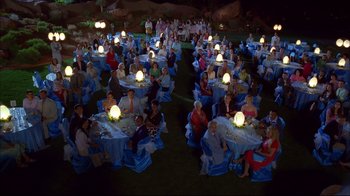 Movie still from “High School Musical 2” (2007), directed by Kenny Ortega – A group of people sitting at tables with lights on top of them; Extreme Wide shot, High angle