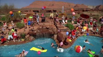 Movie still from “High School Musical 2” (2007), directed by Kenny Ortega – A group of people standing around a swimming pool; Extreme Wide shot, High angle