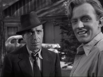 Movie still from “High Sierra” (1940), directed by Raoul Walsh – A man in a suit and a man in a hat; Close Up shot, Over the shoulder angle