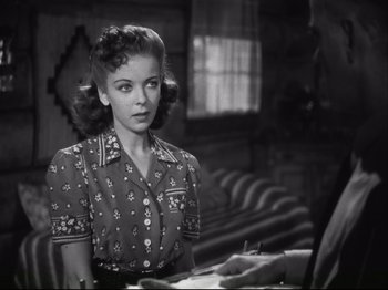 Movie still from “High Sierra” (1940), directed by Raoul Walsh – A black and white photo of a woman looking at the camera; Medium shot, Over the shoulder angle