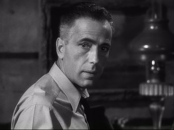 Movie still from “High Sierra” (1940), directed by Raoul Walsh – Black and white photograph of a man in a shirt and tie; Close Up shot, Low angle